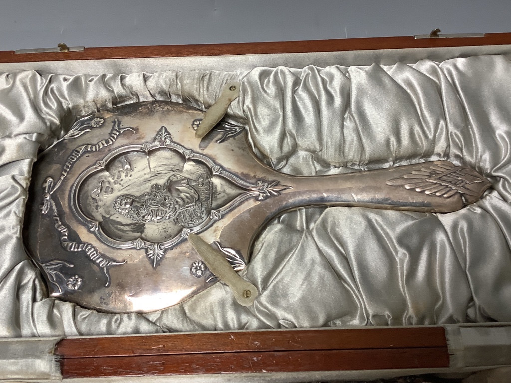 A cased George V silver four piece mirror and brush set, Birmingham, 1912, together with one other brush and a shoe horn.